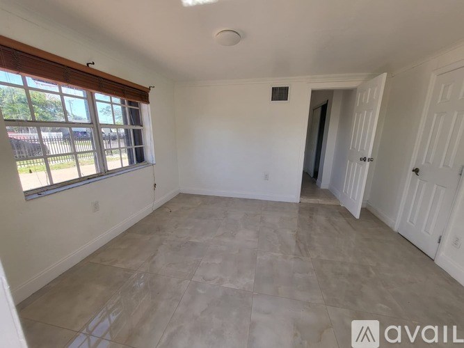 A room with a tiled floor and a window with blinds.