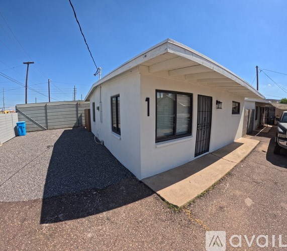 A small white house with a black door and windows is shown.