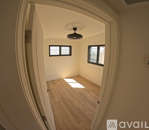 A hallway with wooden floors and white walls.