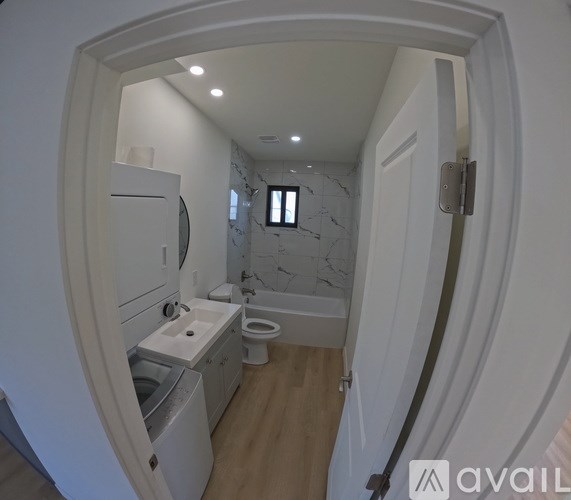 A small bathroom with a toilet, sink, and a washer and dryer.