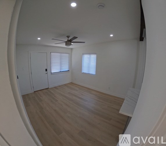 A room with a wooden floor and a ceiling fan.