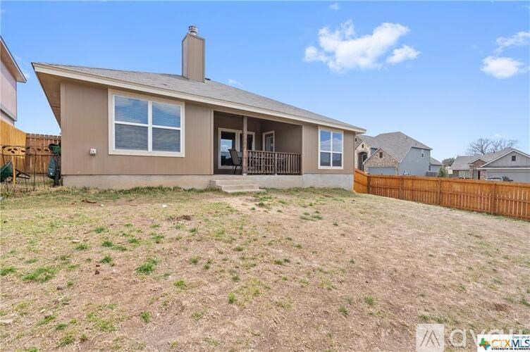 A house with a brown roof and a brown fence.