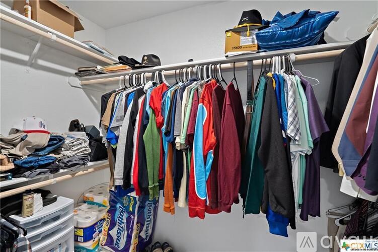 A closet full of clothes hanging on a rail.