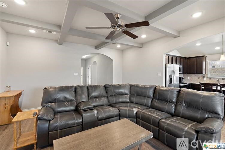 A black leather sectional sofa with a wooden coffee table in the middle of the room.