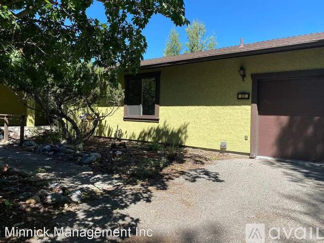 A yellow house with a closed brown garage door.