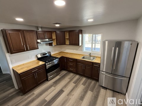 A kitchen with wooden cabinets and a stainless steel refrigerator.