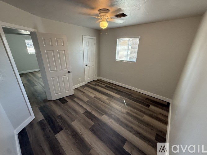 A room with wooden flooring and a ceiling fan.
