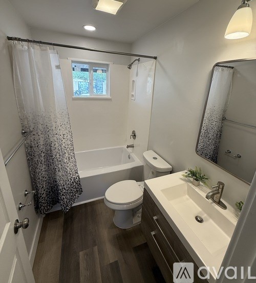 A bathroom with a toilet, sink, and shower.
