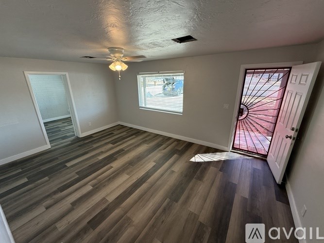 A room with wooden flooring and a ceiling fan.