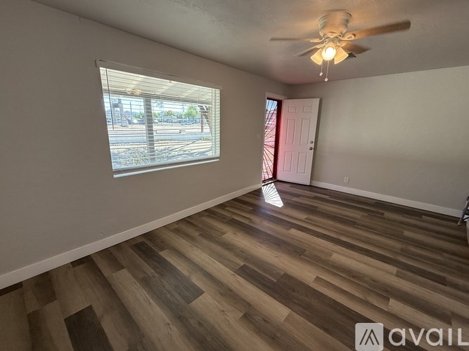 A room with wooden flooring and a ceiling fan.