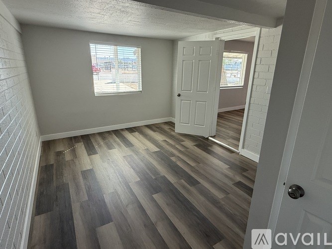 A room with a wooden floor and a white door.