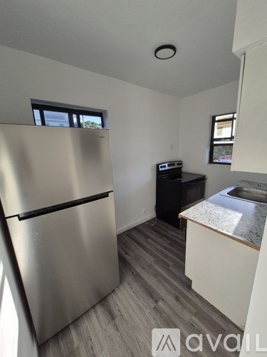 A kitchen with a stainless steel refrigerator and a black dishwasher.