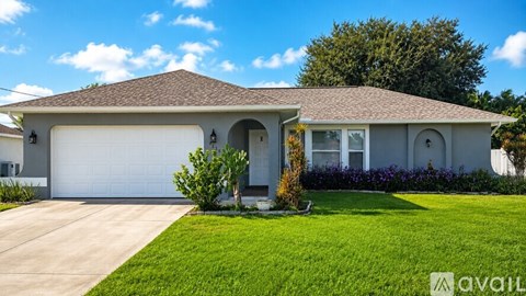 A house with a garage and a driveway in front of it.