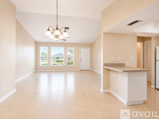 A spacious room with tiled flooring and a ceiling fan.