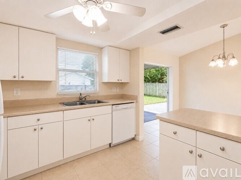 A kitchen with white cabinets and a sink.