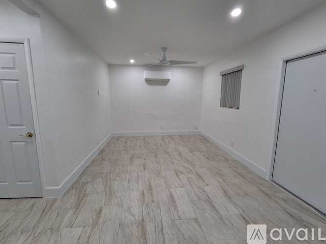 A room with a white door and a ceiling fan.