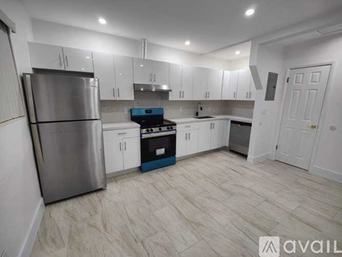 A kitchen with a stainless steel refrigerator and a blue oven.