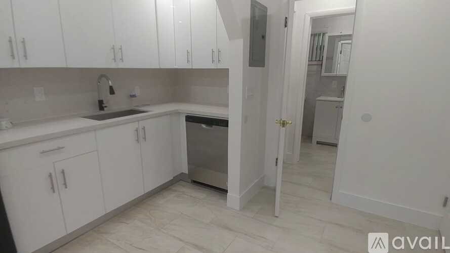 A kitchen with white cabinets and a stainless steel dishwasher.