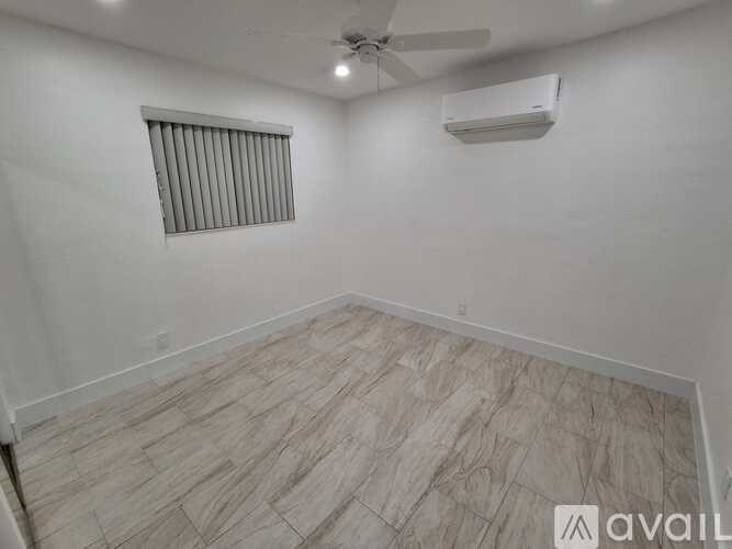 A room with a ceiling fan and air conditioner mounted on the wall.
