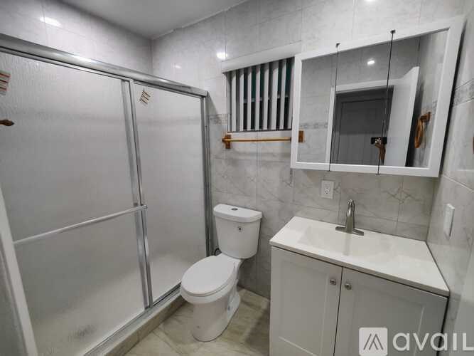 A bathroom with a toilet, sink, and shower.