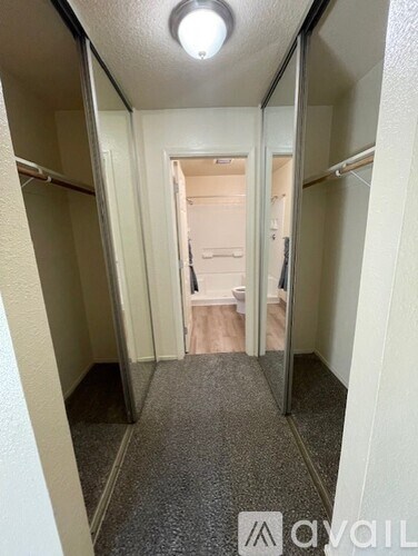 A hallway with a carpeted floor and a light on the ceiling.