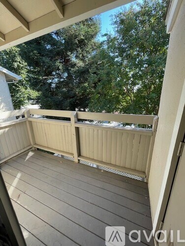 A balcony with a railing and a view of trees.