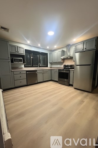 A kitchen with wooden flooring and stainless steel appliances.