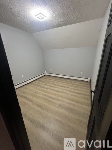 A room with wooden flooring and white walls.