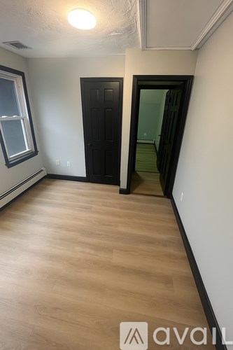 A room with a black door and a window.