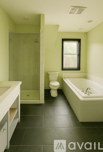 A bathroom with green walls and a white tub.