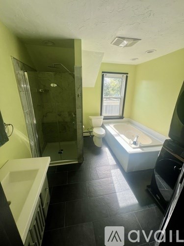 A wooden deck with chairs and a railing overlooking a yard.