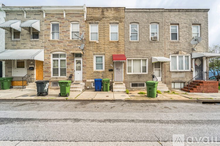 A row of houses with green bins in front.