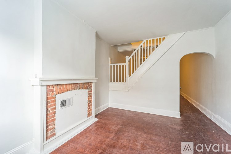 A room with a fireplace and a staircase.