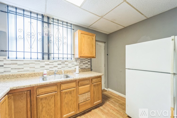 A kitchen with wooden cabinets and a white refrigerator.