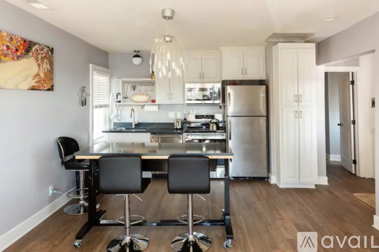 A kitchen with a table and chairs in the foreground and a refrigerator in the background.