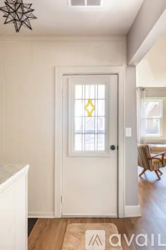 A white door with a diamond shaped window in the middle.