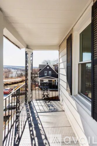A balcony with a metal railing and a tiled floor.
