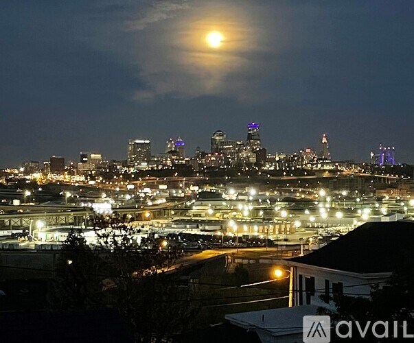 A cityscape at night with a full moon in the sky.