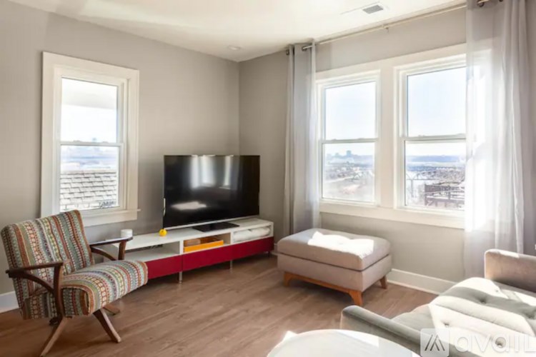 A living room with a television, chair, and ottoman.