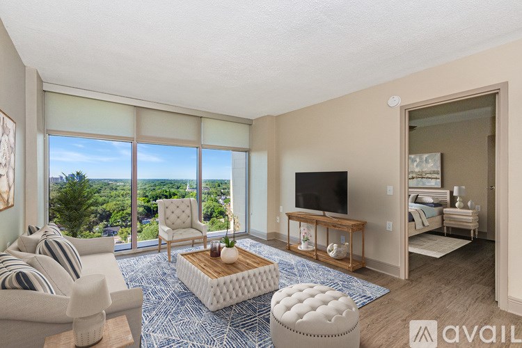 A living room with a large window overlooking a cityscape.