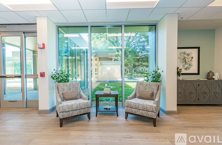 Two chairs and a table are in a room with a view of the outside.