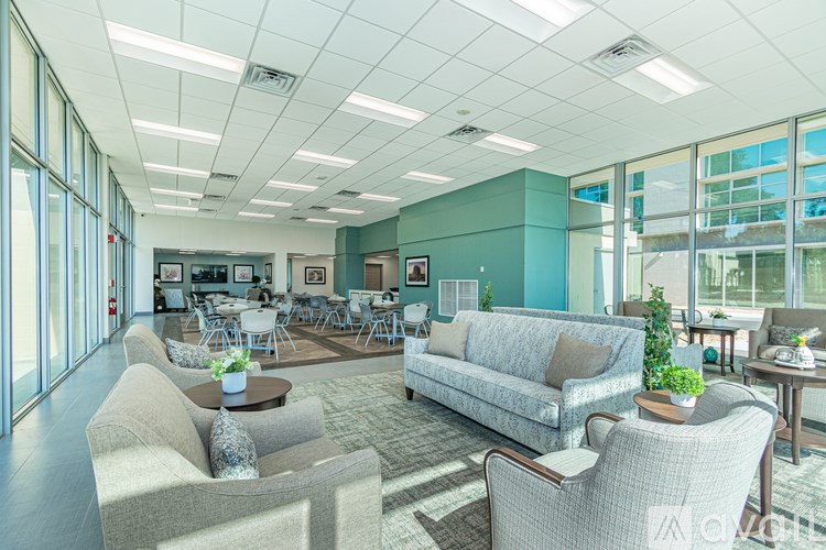 A spacious waiting room with a couch, chairs, and a coffee table.