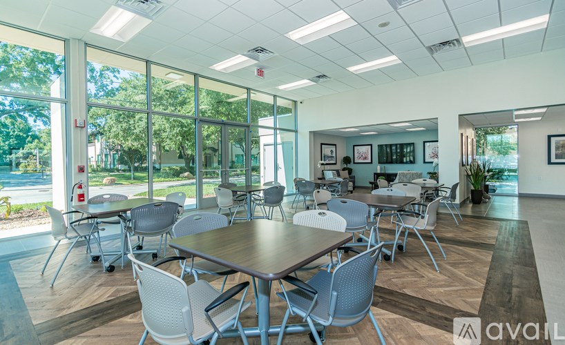 A conference room with a long table surrounded by chairs.
