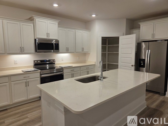 A kitchen with white cabinets and a large island.