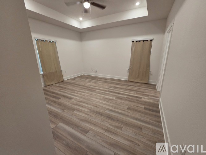 A room with wooden flooring and a ceiling fan.
