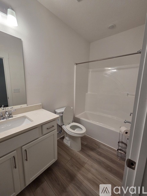 A bathroom with a toilet, sink, and bathtub.