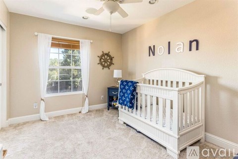 A baby's room with a white crib and a wall decorated with the name "Nolan".