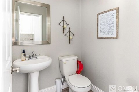 A white toilet sits next to a sink in a bathroom.
