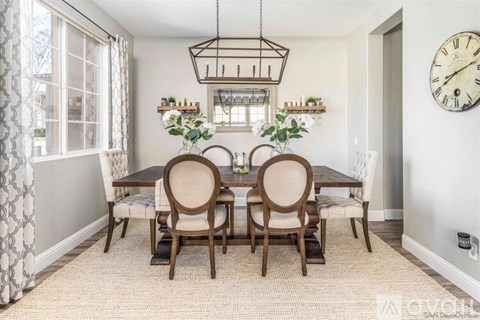 A dining room with a table set for four.