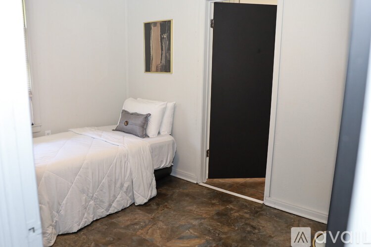 A bedroom with a bed and a painting on the wall.